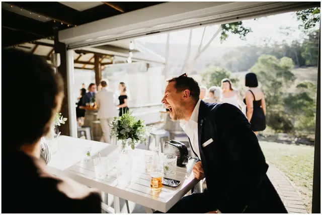 Luke & Cara at Cowbell Creek: The groom smiles across the reception table.